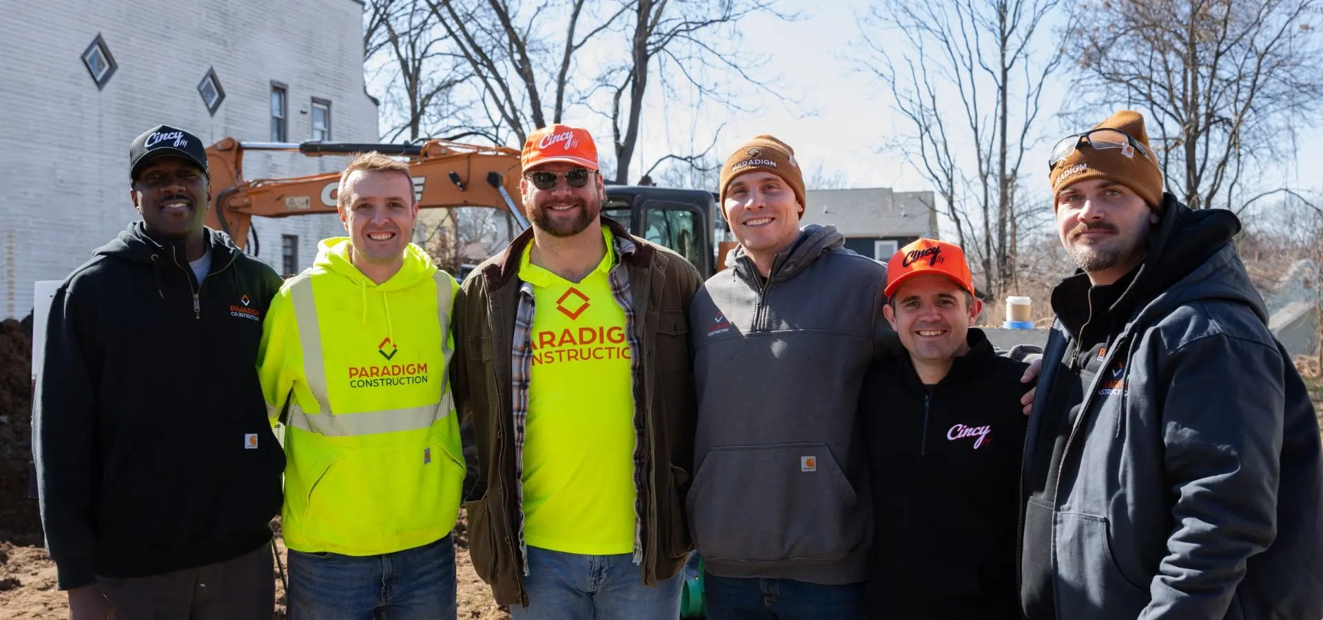 Ted Karras in an orange Cincy hat with Paradigm Construction crew members in hi-vis shirts and friends at the Madisonville groundbreaking