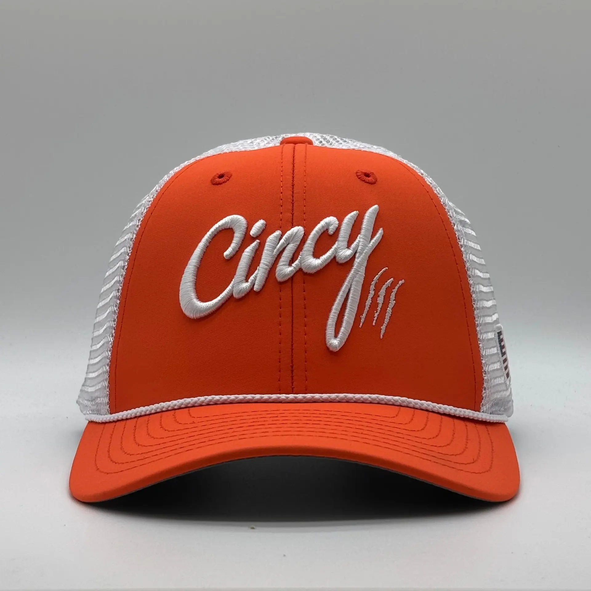 Orange mesh-back rope hat with white Cincy script and claw slashes, a white mesh back and a white rope on the brim, front view on a grey studio backdrop