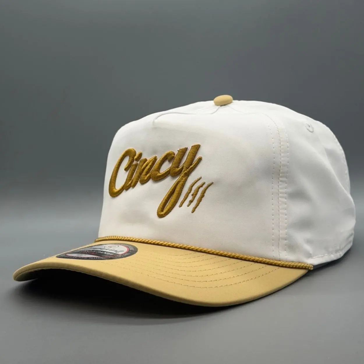 Cream Soft Rope hat with gold Cincy script, a tan brim and a tan rope